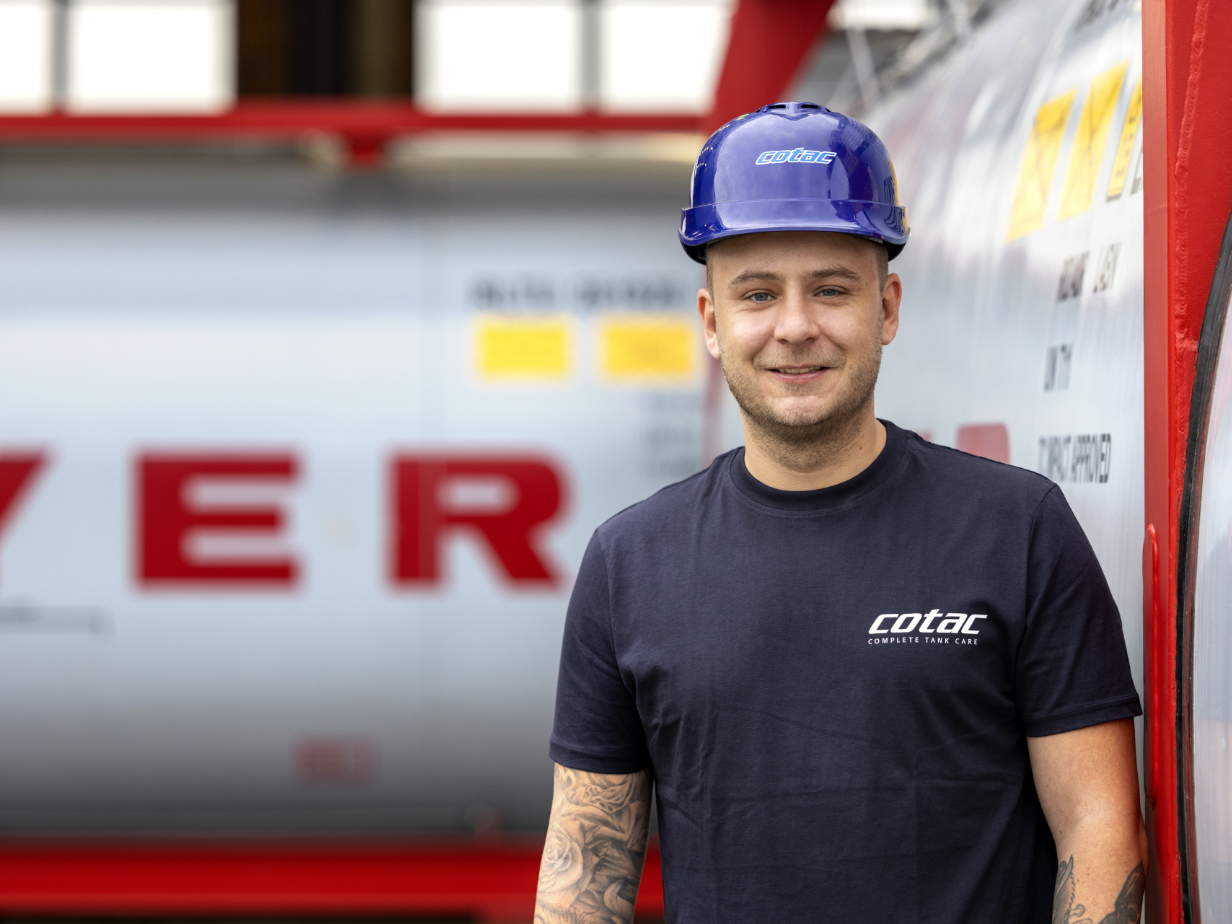 cotac employee with helmet standing in front of a tank container